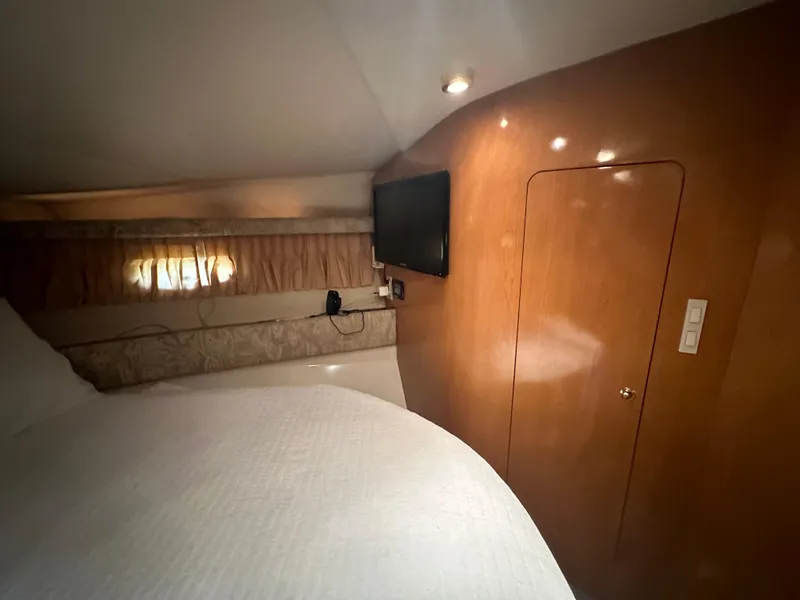 Slide: The Image of 2001 Regal Commodore 3780 cabin interior with bed, TV, and wooden paneling. - 42