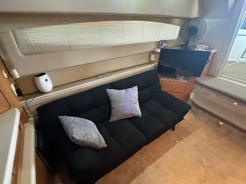 Slide: The Image of Interior of 2001 Regal Commodore 3780 yacht with black sofa, pillows, and TV. - 37