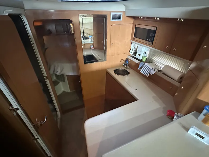 Slide: The Image of Interior of 2001 Regal Commodore 3780 yacht with kitchenette and cozy cabin space. - 38