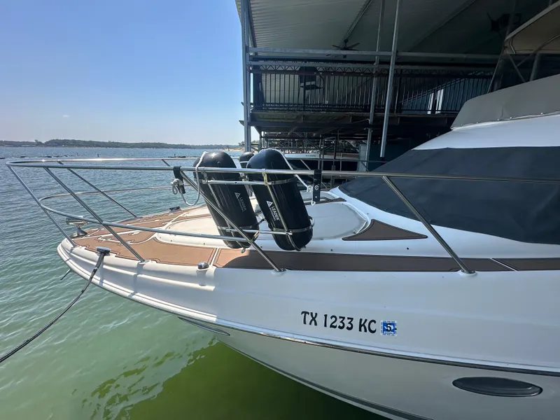Slide: The Image of 2001 Regal Commodore 3780 yacht docked on calm water, featuring sleek design and registration TX 1233 KC. - 11