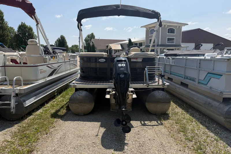 Slide: The Image of 2019 Crest II 230 SL pontoon boat with outboard motor, parked between other boats. - 12
