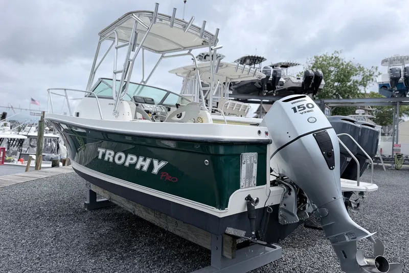 The Image of 2007 Trophy 2002 Walkaround boat with Honda 150 outboard motor, docked on gravel. - 0