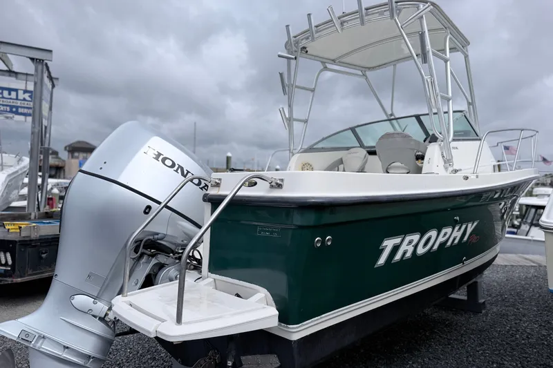 Slide: The Image of 2007 Trophy 2002 Walkaround boat with Honda outboard motor, docked under cloudy skies. - 4