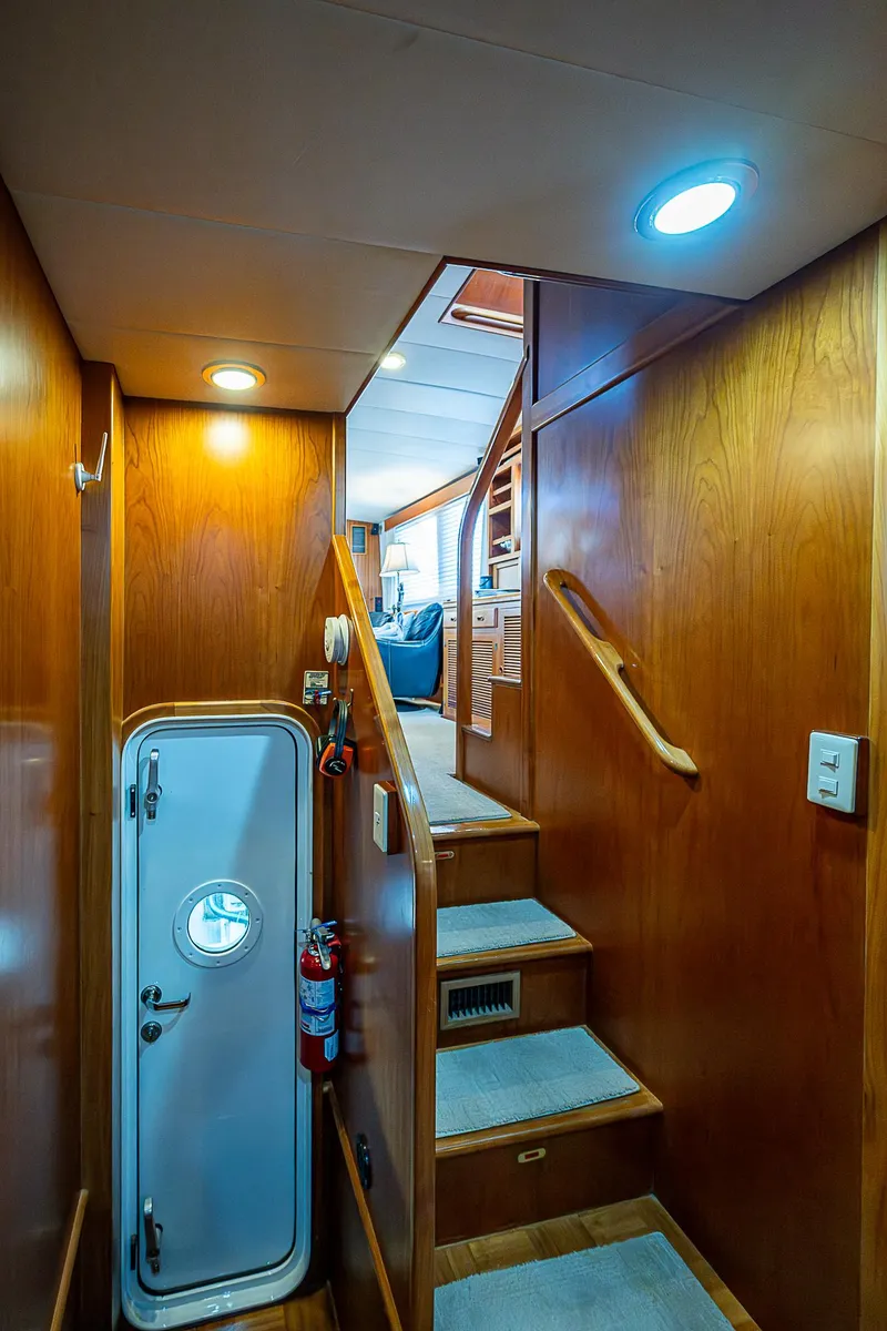 Slide: The Image of Interior of 2001 Kadey-Krogen 58 yacht, featuring wooden stairs and nautical door. - 47