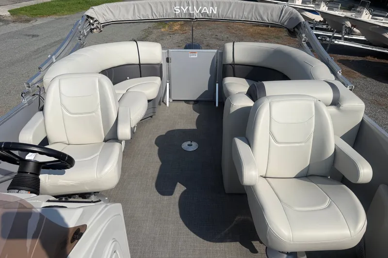 Slide: The Image of 2024 Sylvan Mirage 820 LZ pontoon boat interior with plush seating and steering console. - 10