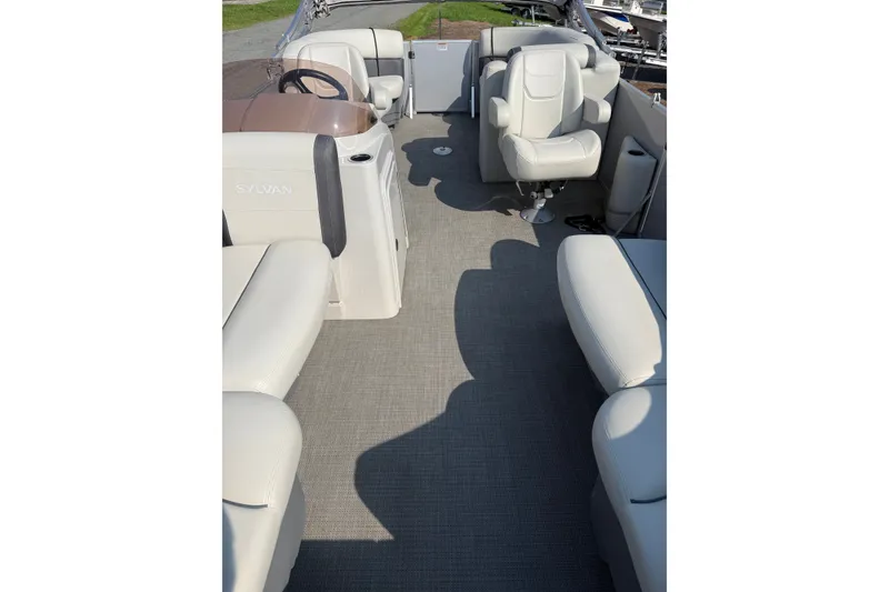 Slide: The Image of 2024 Sylvan Mirage 820 LZ boat interior with plush seating and steering console. - 6