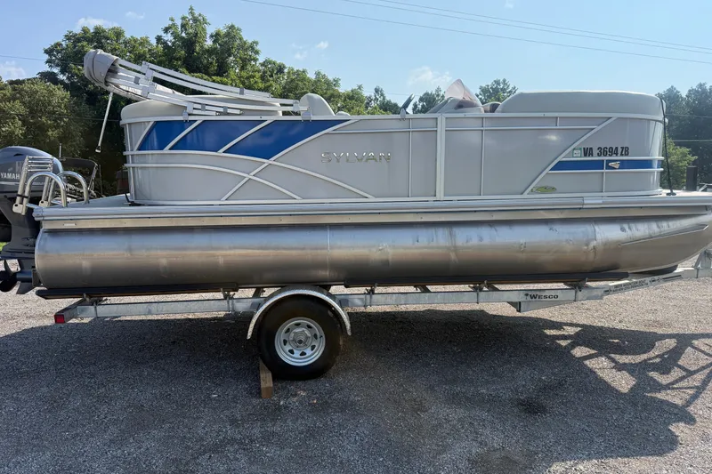 Slide: The Image of 2024 Sylvan Mirage 820 LZ pontoon boat on trailer, side view, outdoors. - 1