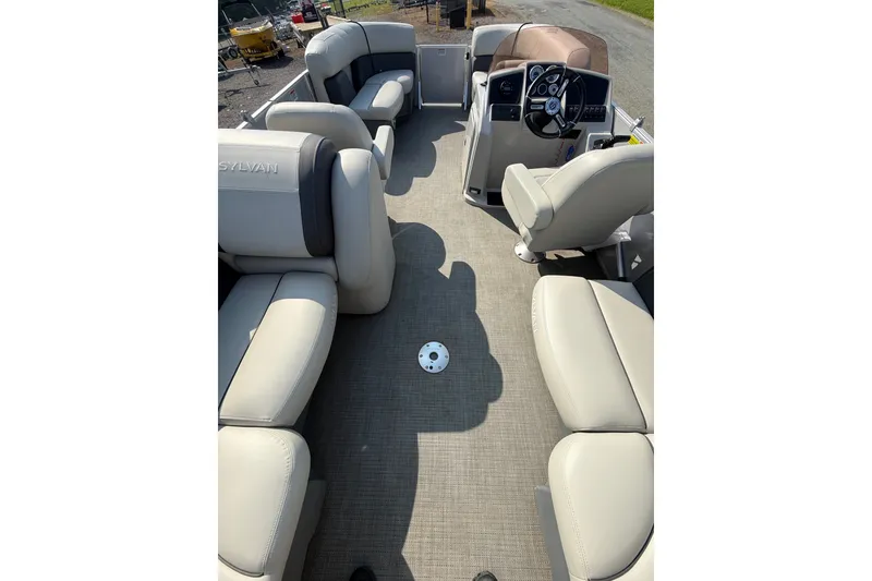 Slide: The Image of 2024 Sylvan Mirage 820 LZ pontoon boat interior with plush seating and steering console. - 12