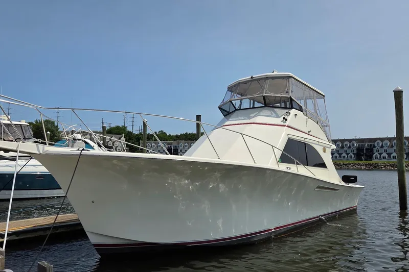Slide: The Image of 1989 Jersey 42 Convertible Sportfisherman boat docked in marina under clear sky. - 2