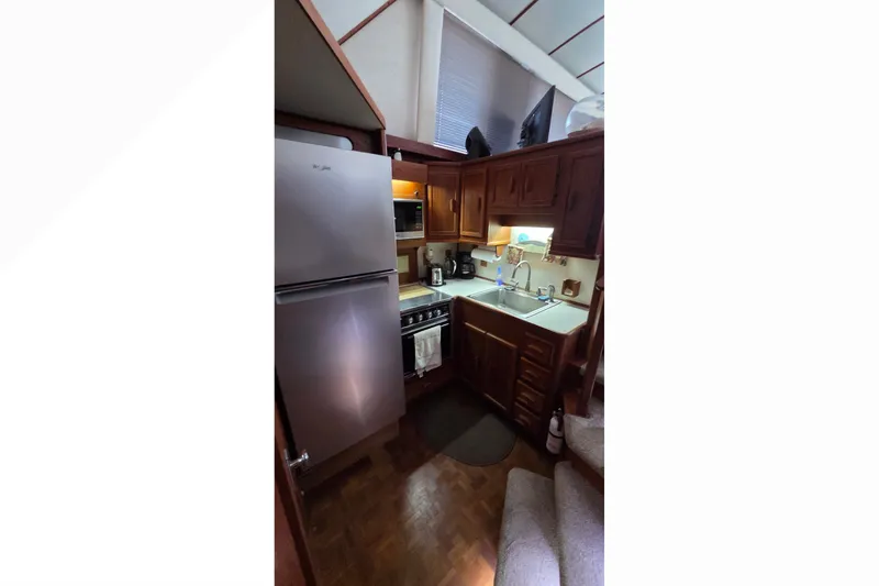 Slide: The Image of Interior of 1989 Jersey 42 Convertible Sportfisherman, featuring a compact kitchen with appliances. - 11