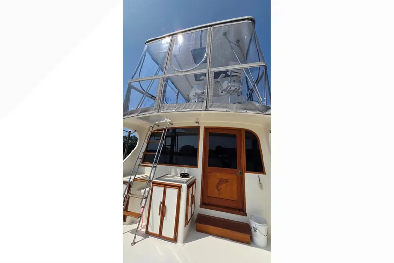 Slide: The Image of 1989 Jersey 42 Convertible Sportfisherman with flybridge and wooden accents under clear blue sky. - 5