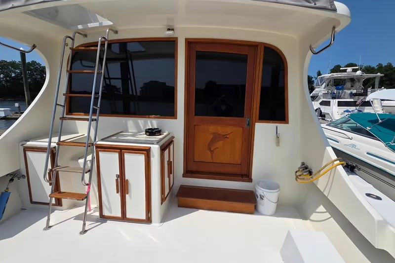 Slide: The Image of 1989 Jersey 42 Convertible Sportfisherman yacht deck with ladder and wooden door. - 4