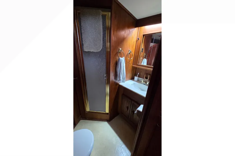 Slide: The Image of 1989 Jersey 42 Convertible Sportfisherman bathroom with wood paneling and shower. - 16