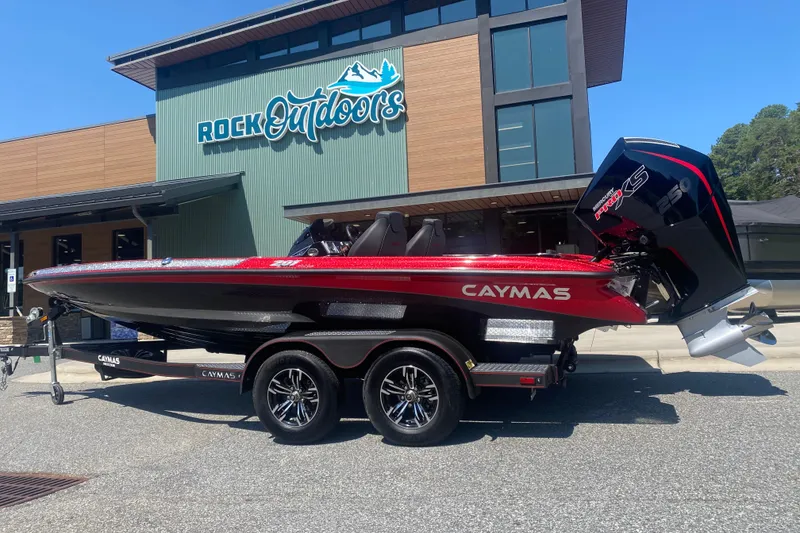 The Image of 2027 Caymas 201 Pro boat in red, parked outside Rock Outdoors store. - 0