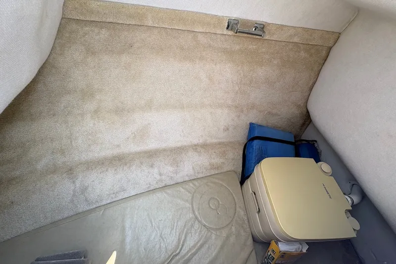 Slide: The Image of Interior cabin of 2005 Regal 2600 LSR boat with portable toilet and storage. - 13