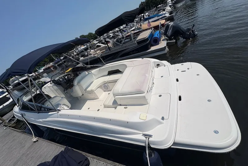 Slide: The Image of 2005 Regal 2600 LSR boat docked, featuring spacious seating and dual bimini tops. - 2