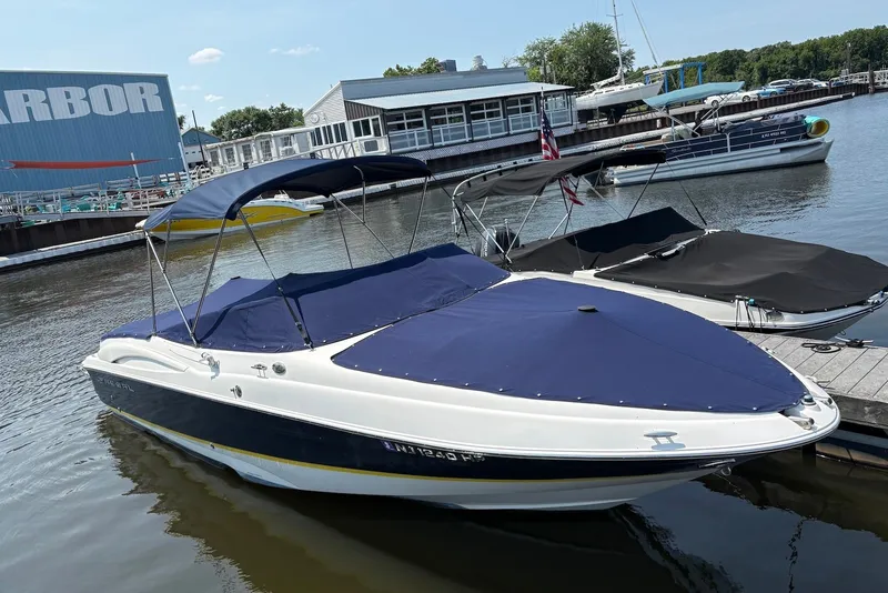 The Image of 2005 Regal 2600 LSR boat docked at marina with blue cover and canopy. - 0