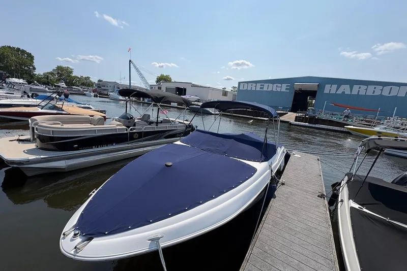 Slide: The Image of 2005 Regal 2600 LSR boat docked at Dredge Harbor marina under clear skies. - 1