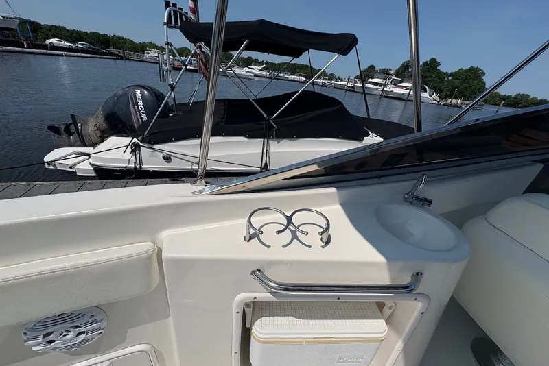 Slide: The Image of 2005 Regal 2600 LSR boat interior with sink and docked Mercury engine boat. - 9