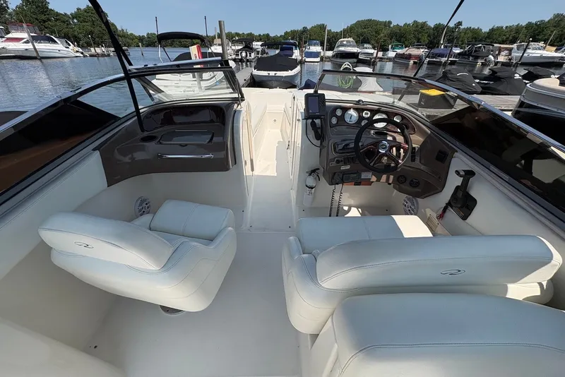 Slide: The Image of 2005 Regal 2600 LSR boat interior with white seating and control panel at marina. - 10