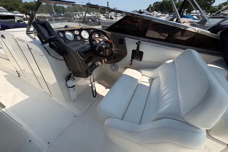 Slide: The Image of 2005 Regal 2600 LSR boat cockpit with steering wheel and white seating. - 12