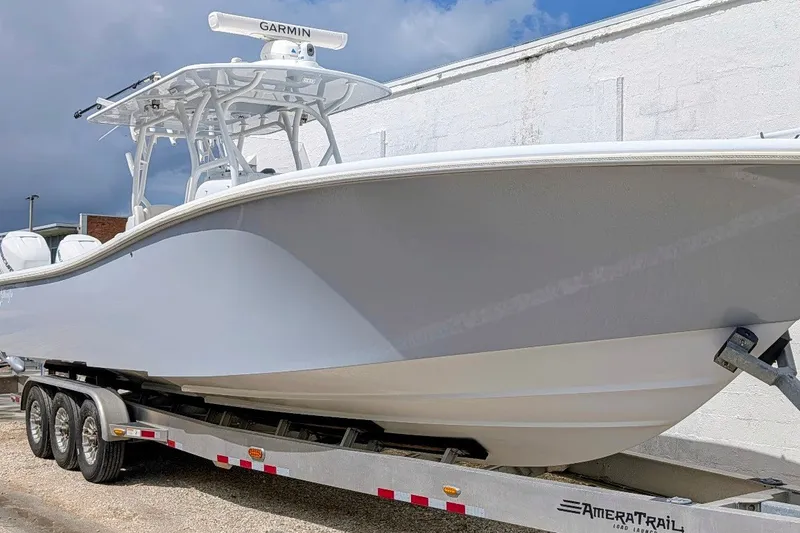 The Image of 2022 Yellowfin 36 Offshore boat on trailer, featuring Garmin equipment, against a cloudy sky. - 0