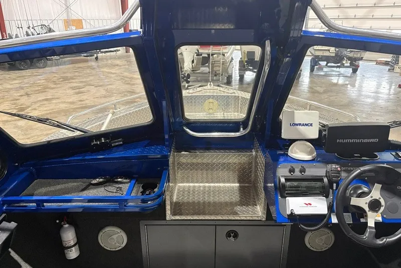 Slide: The Image of Interior view of 2013 Northwest Boats 228 Lightning Outboard, featuring navigation equipment and steering controls. - 19