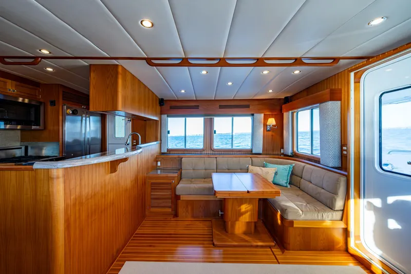Slide: The Image of Starboard side saloon with teak hi-lo table. The pop-up TV rises from behind the settee - 10