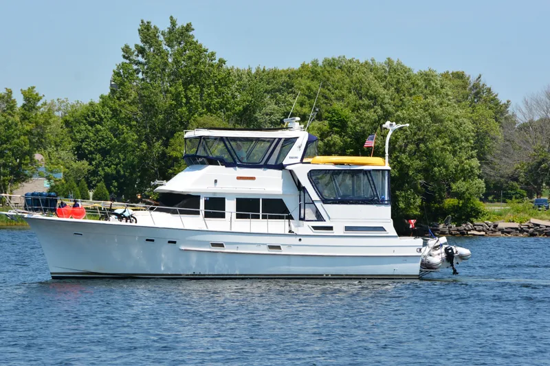 Slide: The Image of 1985 Jefferson yacht cruising on a serene lake with lush green trees in the background. - 3
