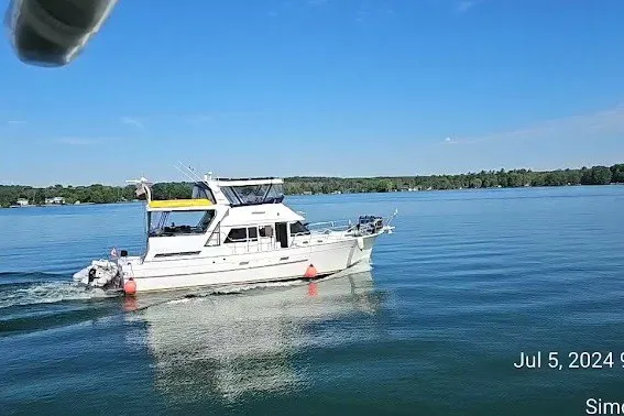 Slide: The Image of A 1985 Jefferson boat cruising on a serene lake under a clear blue sky. - 2