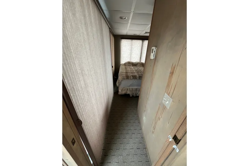 Slide: The Image of Narrow hallway leading to a bedroom inside a 2009 custom tritoon boat. - 13