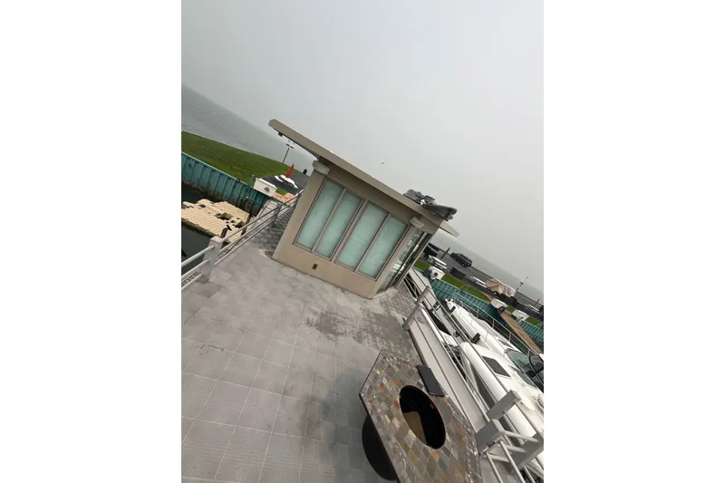 Slide: The Image of Rooftop view with modern patio, overlooking water and docked boats. - 28