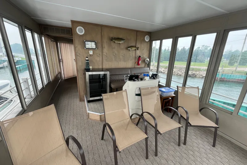 Slide: The Image of Interior of a 2009 custom tritoon with chairs and helm, overlooking water. - 22