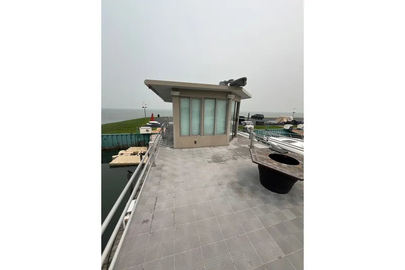 Slide: The Image of Rooftop view of a 2009 custom tritoon with modern design and waterfront scenery. - 27