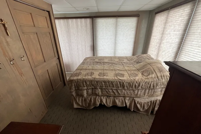 Slide: The Image of Cozy bedroom with patterned bedspread, wooden closet, and soft lighting in a 2009 custom tritoon. - 17