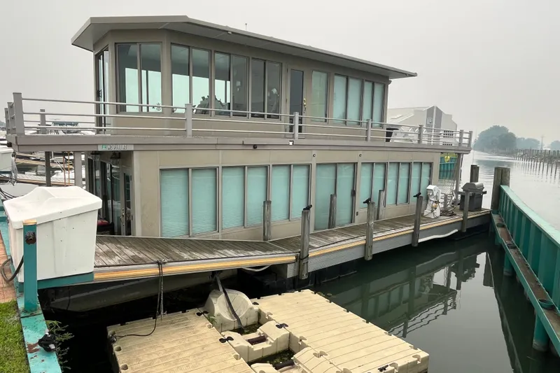 Slide: The Image of Modern 2009 custom tritoon houseboat docked at marina, featuring large windows and upper deck. - 0