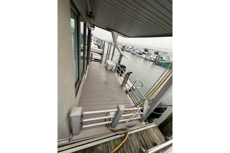 Slide: The Image of Custom 2009 tritoon boat docked, featuring spacious deck and modern railing. - 3