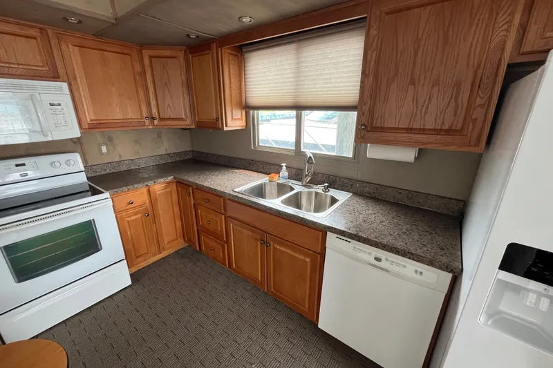 Slide: The Image of Kitchen interior of a 2009 custom tritoon with wooden cabinets and modern appliances. - 9