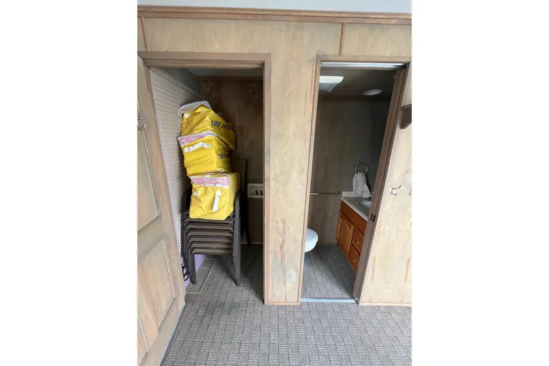 Slide: The Image of Interior of a 2009 custom tritoon with storage and bathroom area. - 32