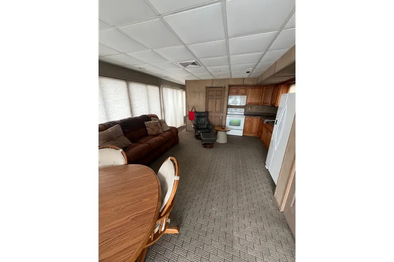 Slide: The Image of Interior of a 2009 custom tritoon with kitchen, dining area, and comfortable seating. - 5