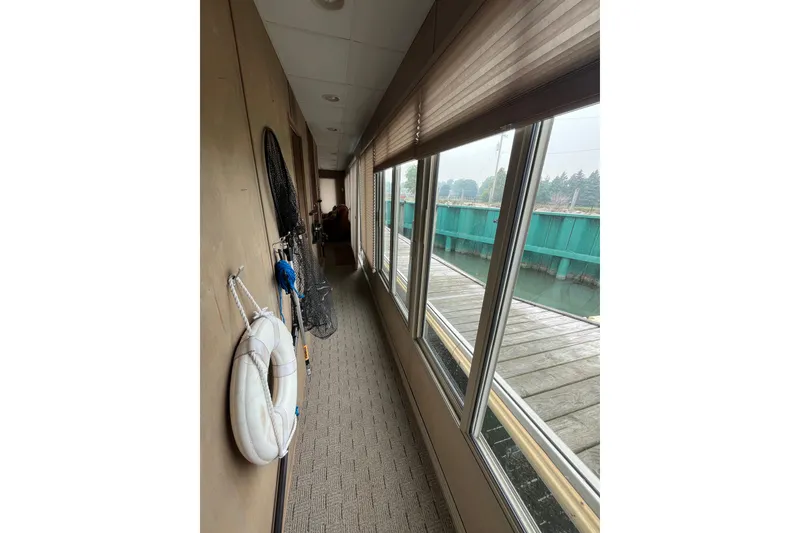 Slide: The Image of Narrow hallway on a 2009 custom tritoon boat with large windows and fishing gear. - 18