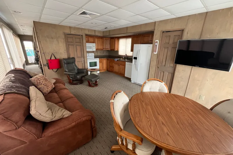 Slide: The Image of Interior of a 2009 custom tritoon with kitchen, dining area, and seating. - 6