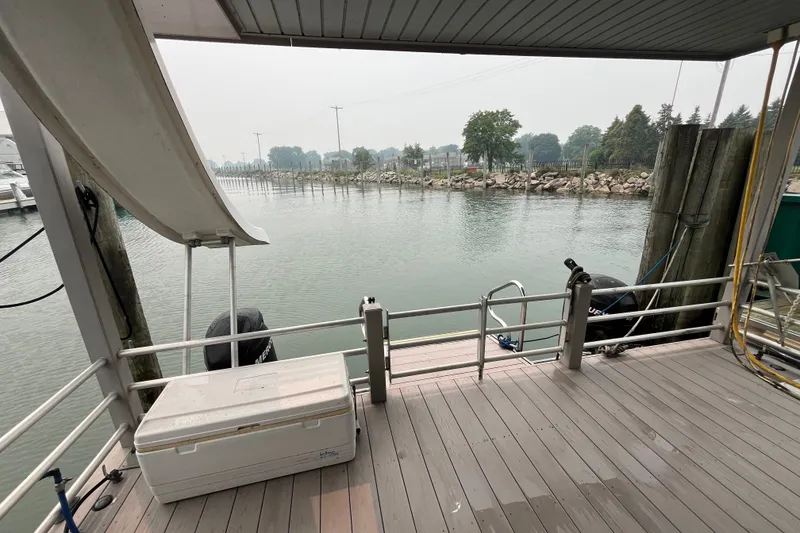 Slide: The Image of 2009 Custom tritoon boat deck with slide, overlooking calm waters and shoreline. - 4