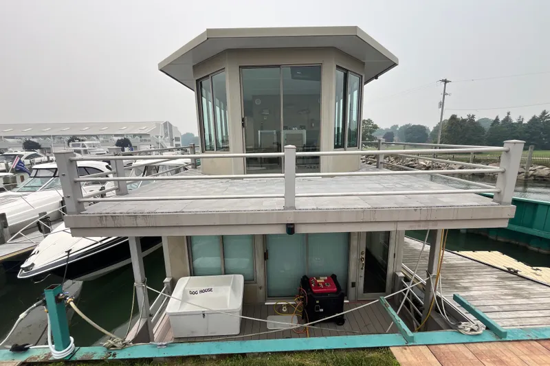 Slide: The Image of Custom 2009 tritoon houseboat with upper deck, docked at marina, featuring modern design. - 2