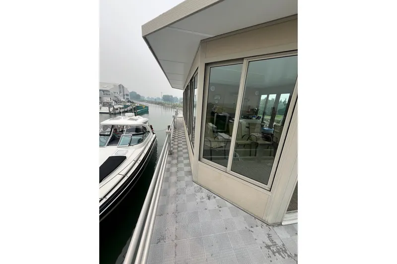Slide: The Image of Custom 2009 tritoon docked beside modern waterfront building with large windows. - 25