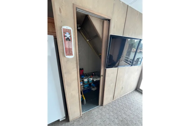Slide: The Image of Interior of a 2009 custom tritoon with a wall-mounted TV and storage area. - 7