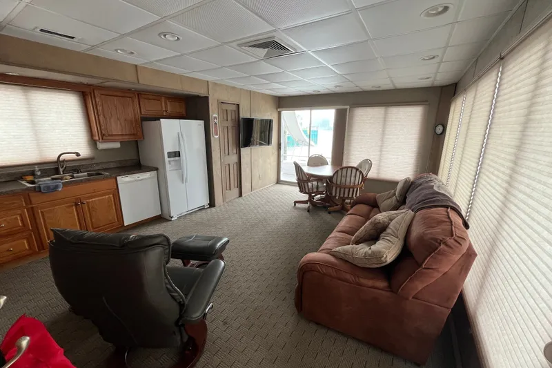 Slide: The Image of Interior of a 2009 custom tritoon with kitchen, seating area, and dining table. - 8