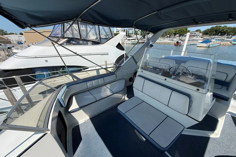 Slide: The Image of 1989 Carver 340 Santego boat interior with seating and steering wheel, docked at marina. - 12