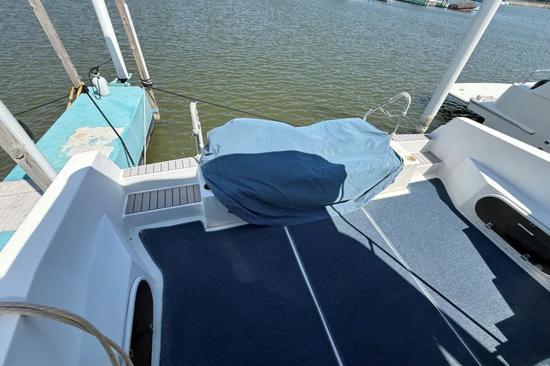 Slide: The Image of 1989 Carver 340 Santego boat deck with blue carpet and covered seating area. - 5
