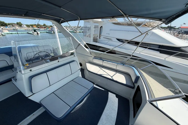 Slide: The Image of 1989 Carver 340 Santego boat interior with seating and steering wheel, docked at marina. - 11